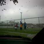 Kids watching football practice.